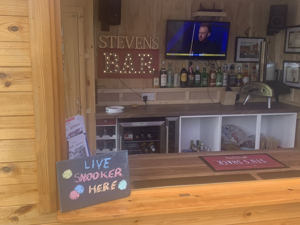 Photo of Stu's Shack with snooker on in the background.