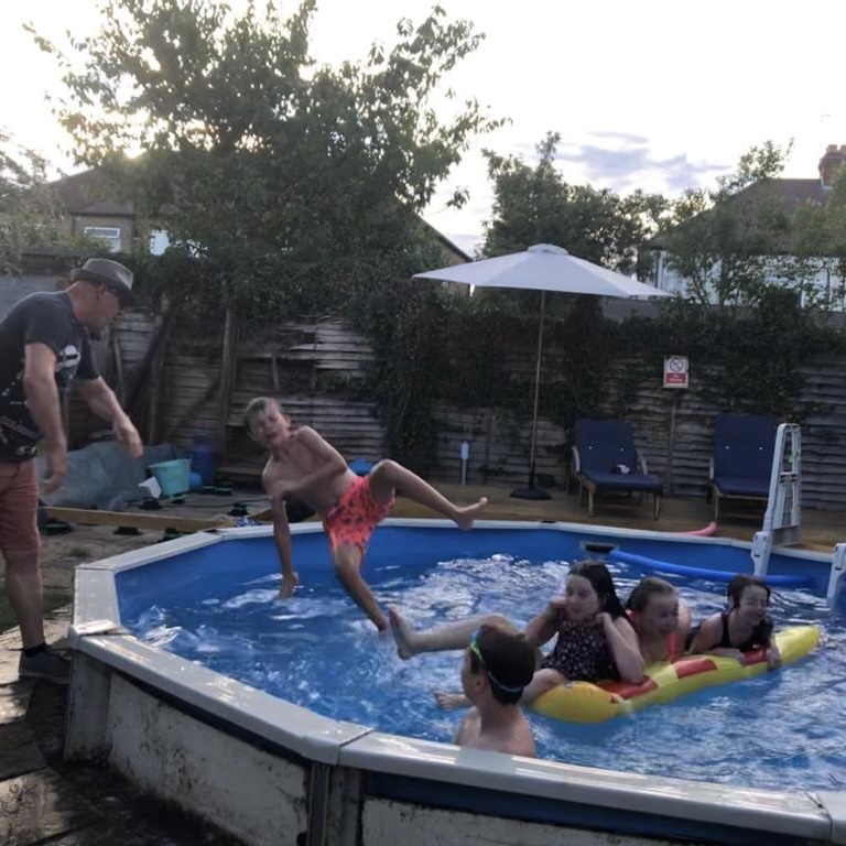 Image of small childern being thrown into the pool.